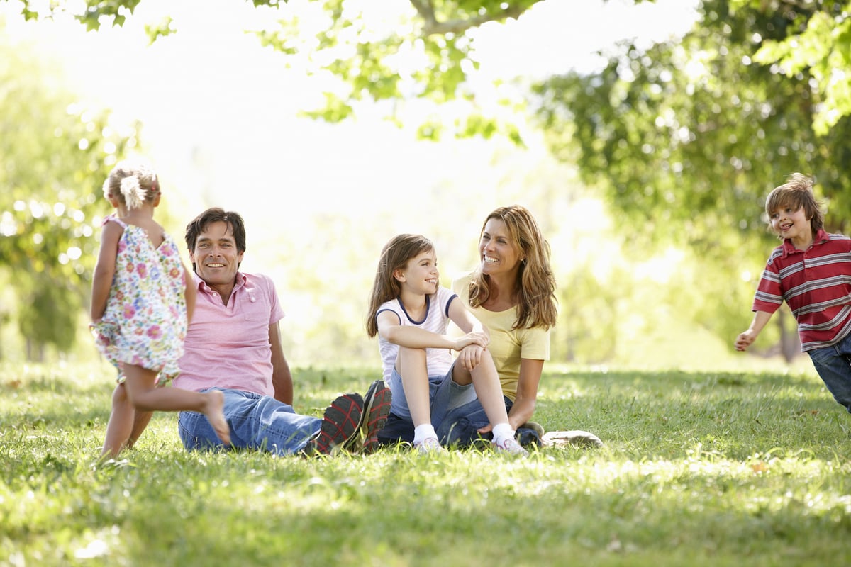 family playing and sitting on lawn together