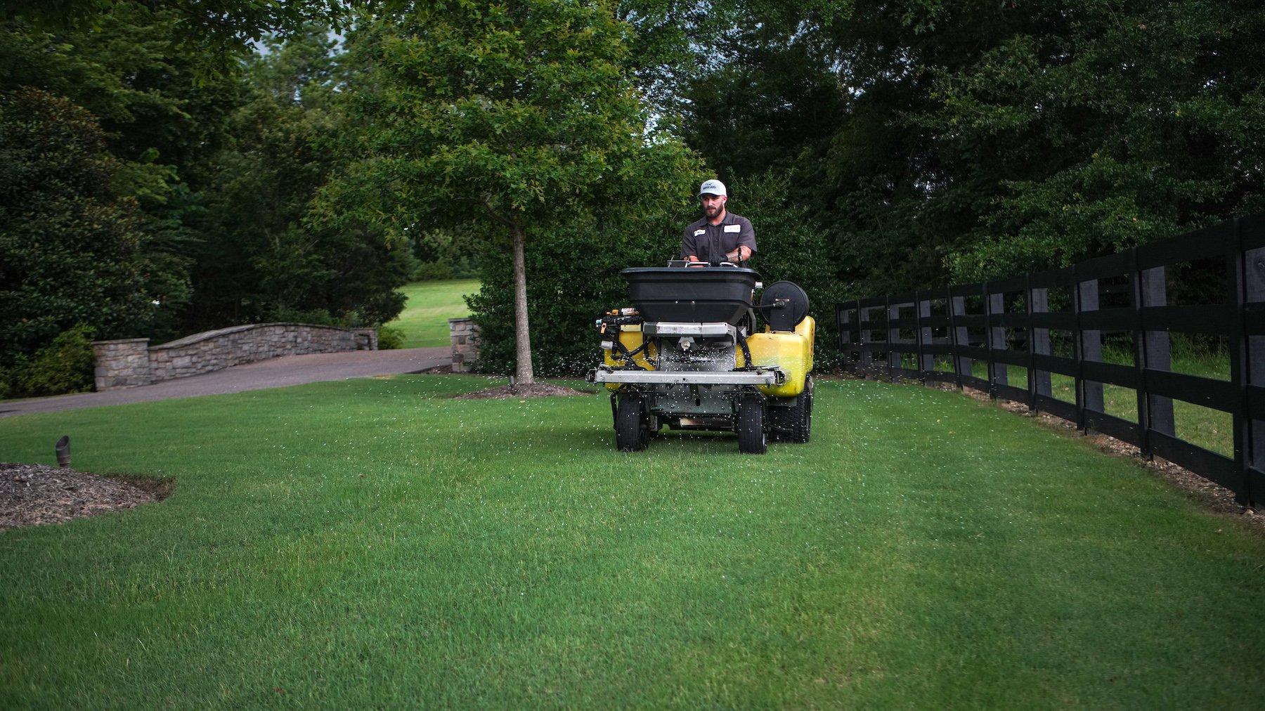 lawn care technician applying fertilizer 