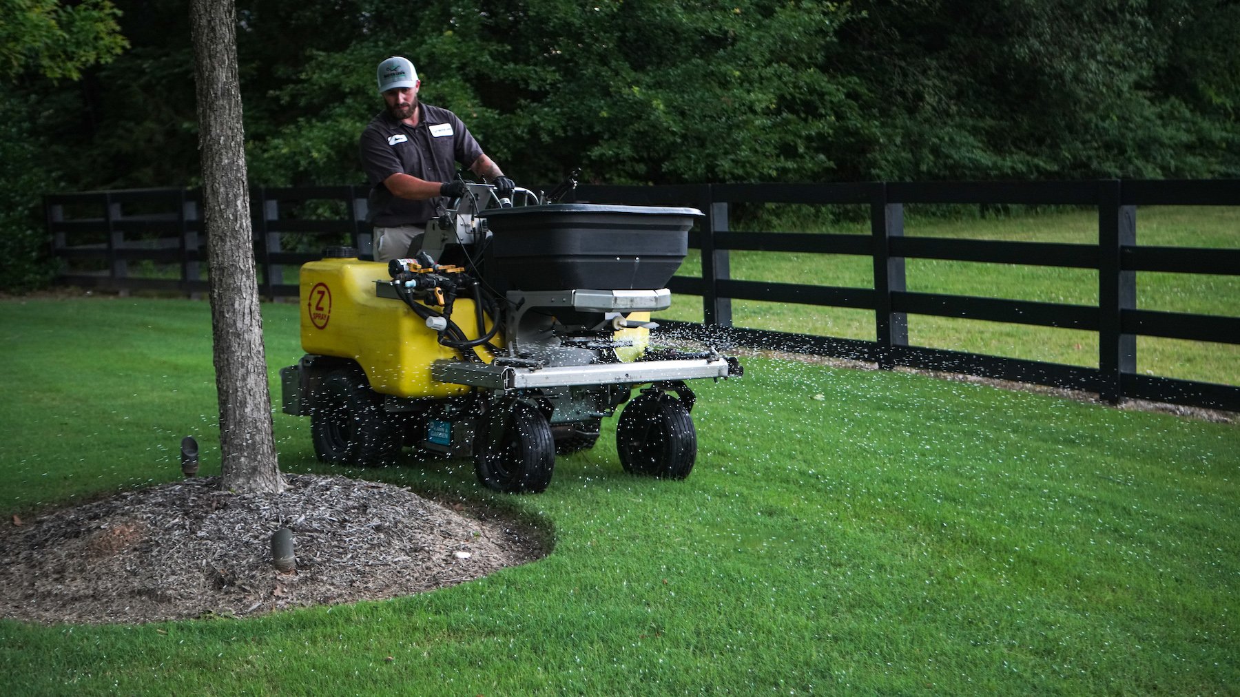 lawn care technician applying fertilizer