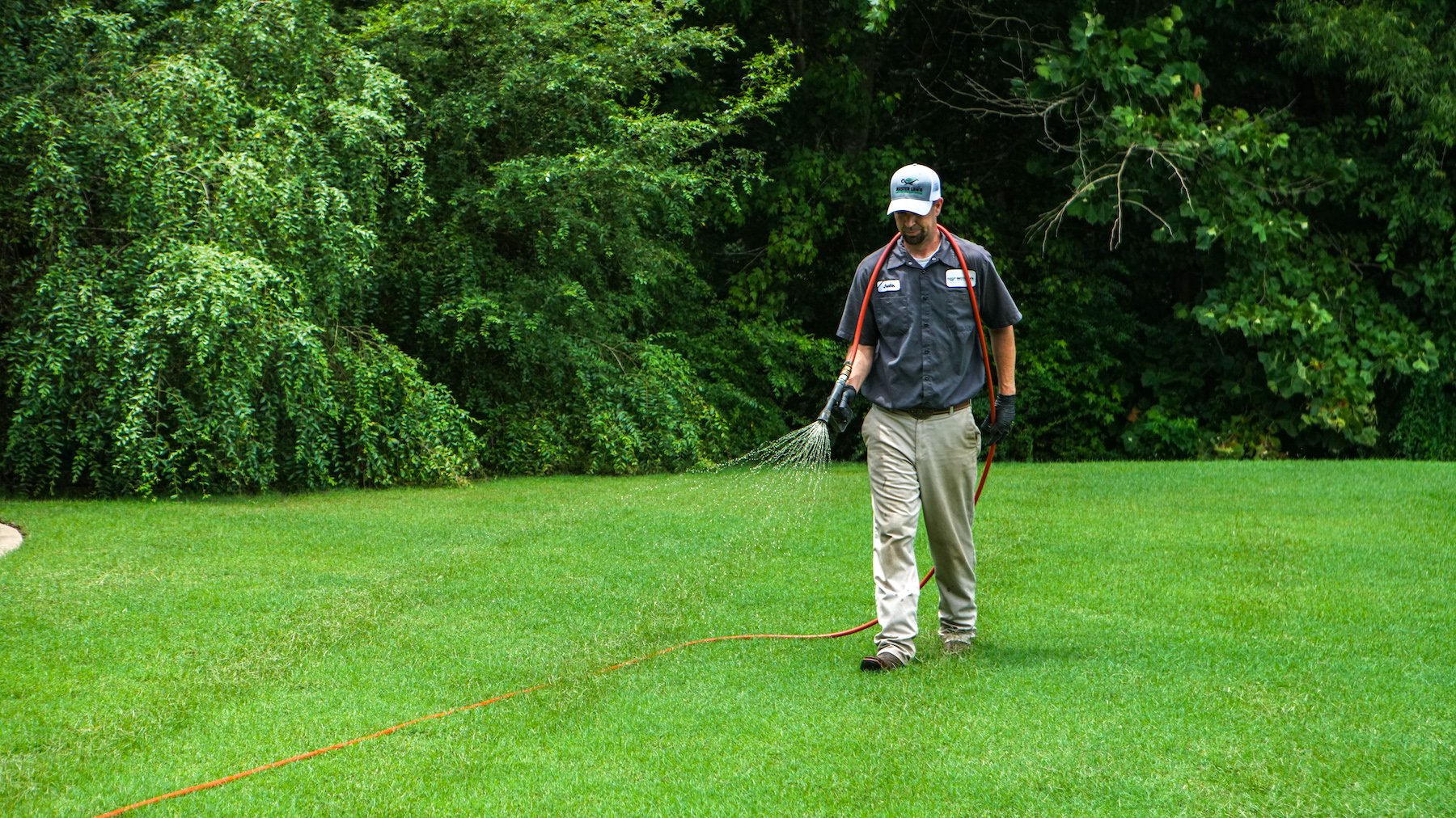 lawn care technician spraying weed control