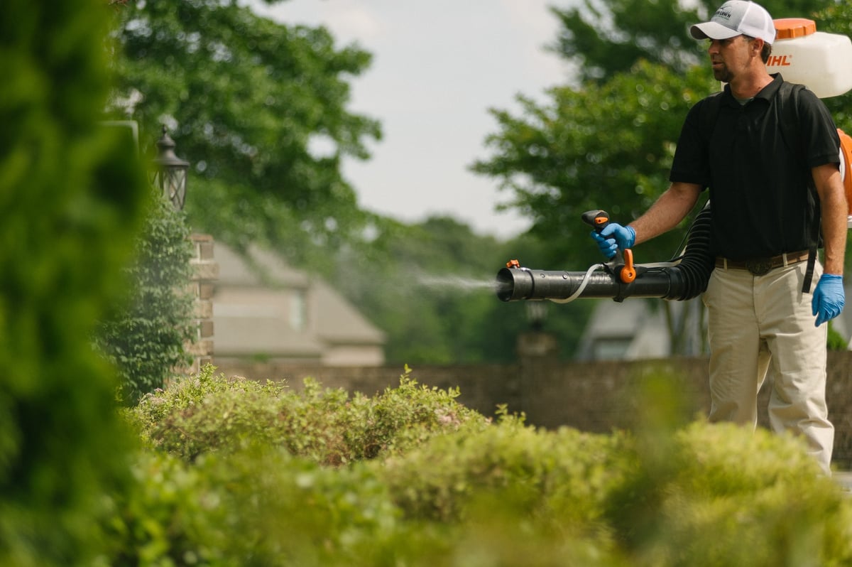 technician sprays for mosquitoes