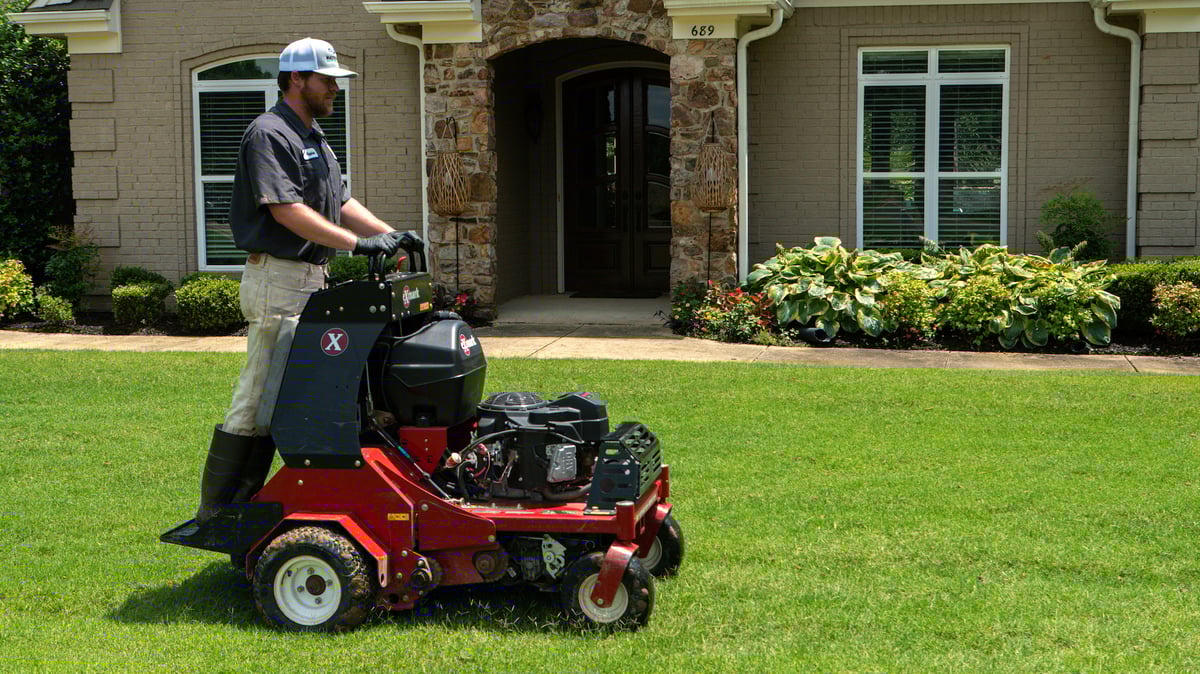 lawn care technician aerates lawn