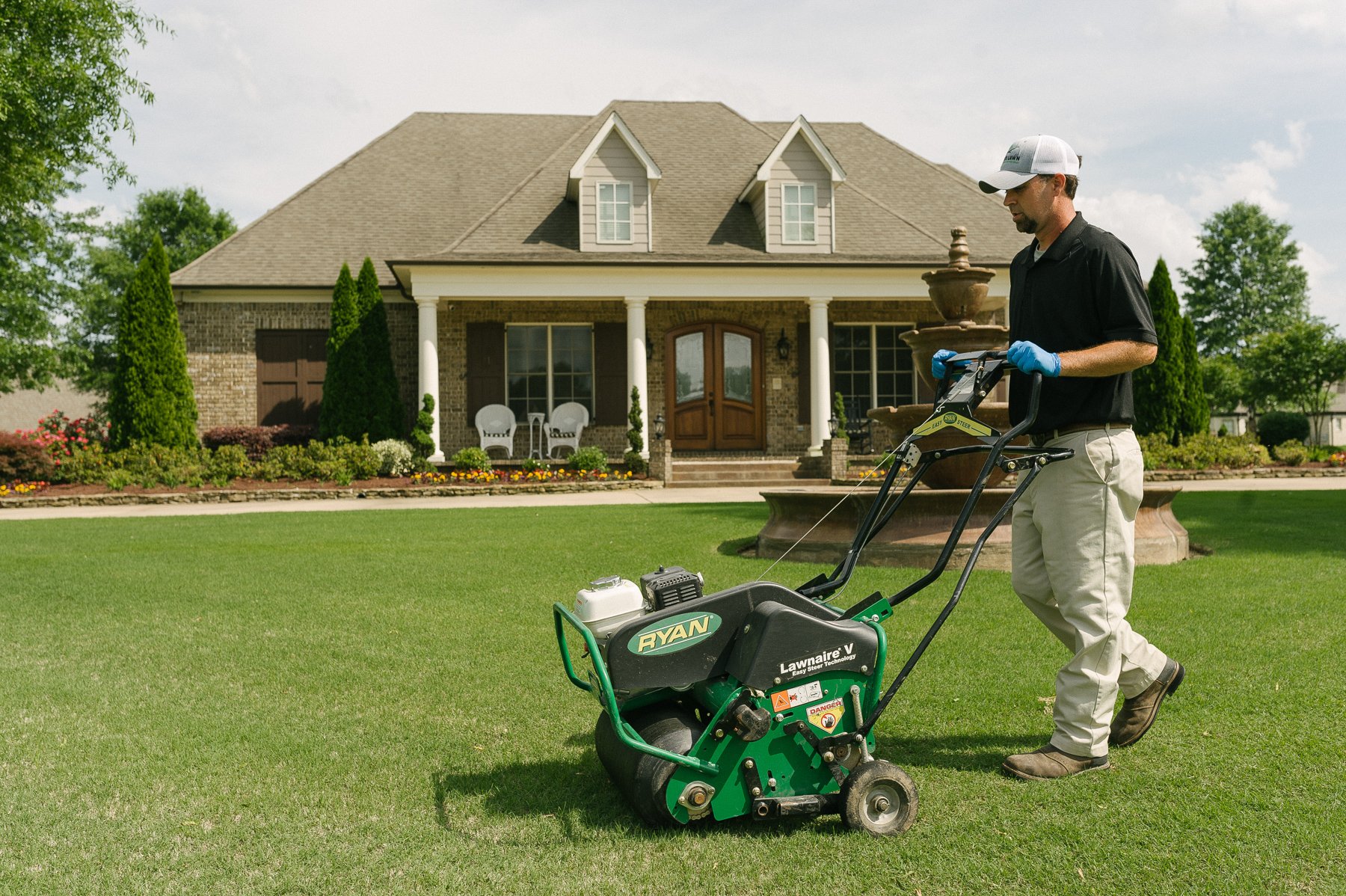 lawn care technician aerating lawn