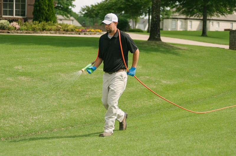 Lawn care technician spraying lawn