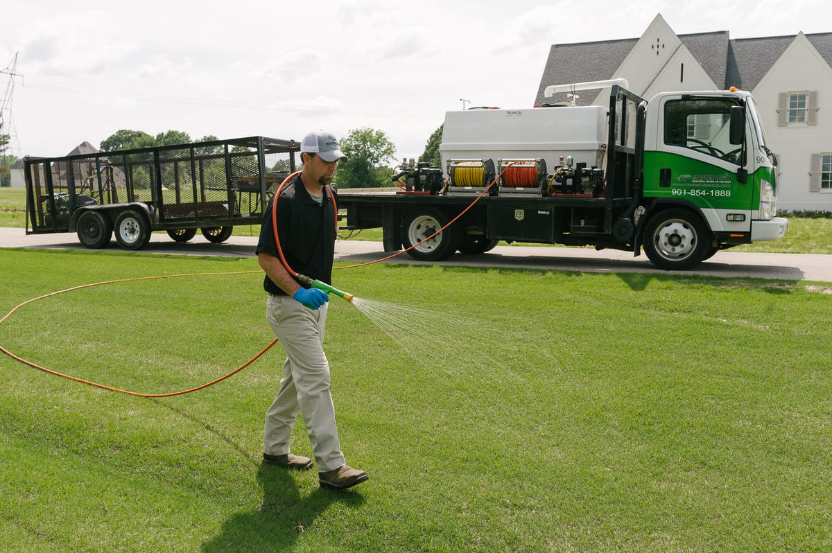 lawn care technician spraying lawn