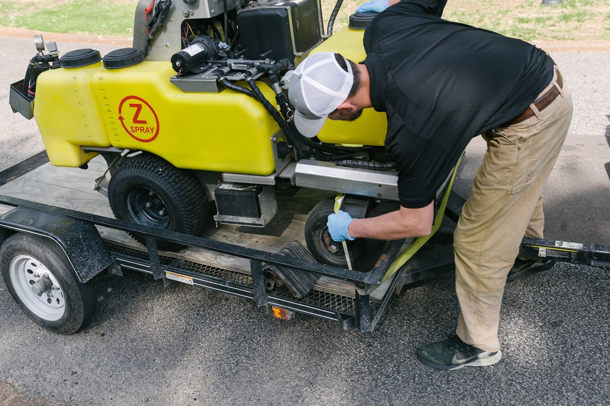 lawn technician unloads professional liquid fertilization equipment