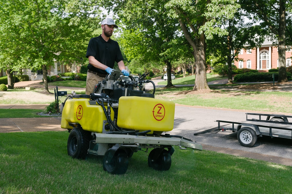 Lawn technician spraying liquid fertilizer