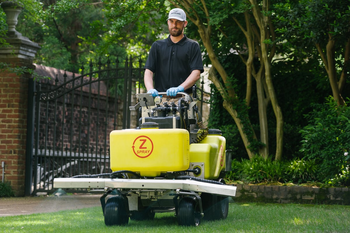 lawn care professional applies liquid fertilizer