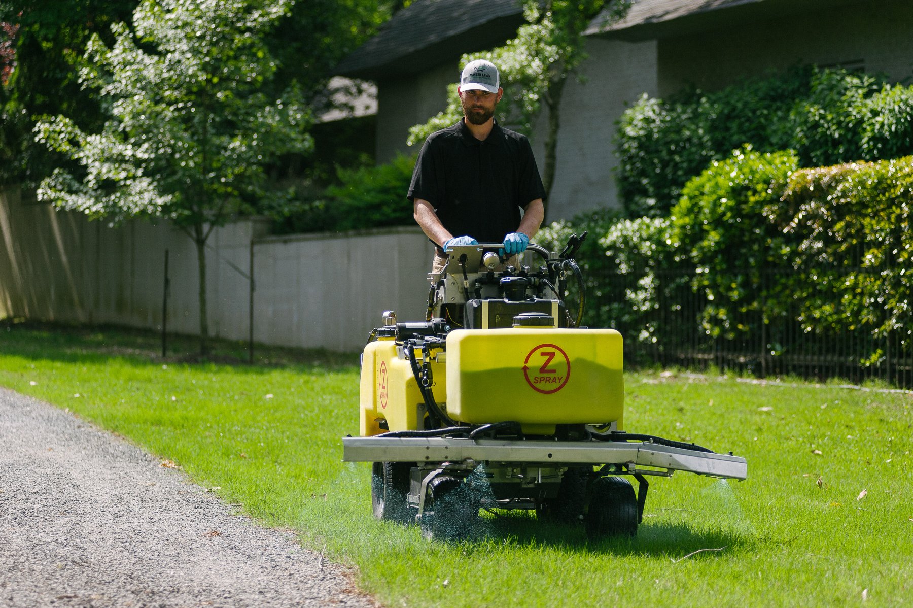 lawn care technician applying liquid fertilizer