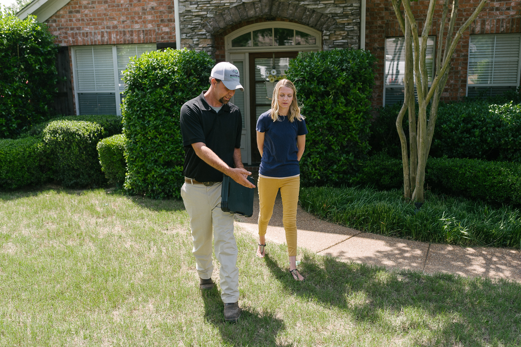 lawn care technician discusses lawn disease with client